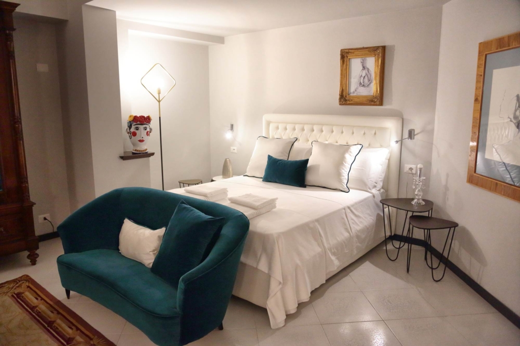 Suite mit Terrasse in Taormina: Doppelbett und grünes Samtsofa